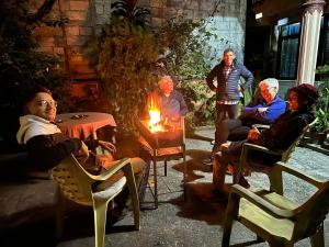 a group of people sitting around a fire at Hotel Diplomat in Pokhara