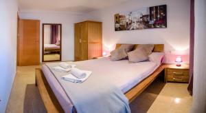 a bedroom with a large bed with two towels on it at Parrot’s House in Lloret de Mar