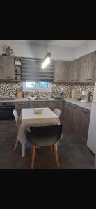 eine Küche mit einem weißen Tisch und Stühlen in der Unterkunft Pines Flat in Fourka