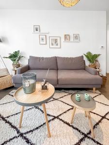 a living room with a couch and two tables at Charme et confort à Bondy - proche Paris Disney CDG in Bondy