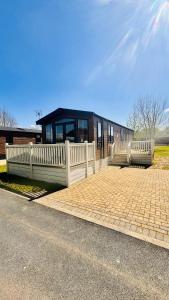 a building with a white fence on the side of the road at Lottie's Lodge With Hot Tub in Malton
