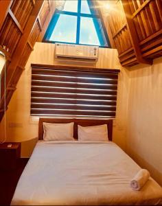 ein Schlafzimmer mit einem großen Bett mit Fenster in der Unterkunft Hill View 'A'Frame Villa Wayanad in Vythiri