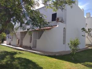 a side view of a white building with a yard at Apartamento Almargem in Conceição