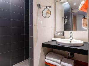 une salle de bain avec un lavabo et un miroir dans l'établissement Mercure Paris Gare De Lyon TGV, à Paris 37 autres photos