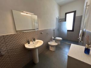 a bathroom with a sink and a toilet and a mirror at Marisol in Marsala