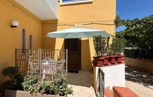 a patio with an umbrella and some plants at Marisol in Marsala