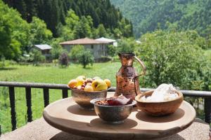 a table with two bowls of fruit and a vase at Guesthouse Mareti in Shuakhevi