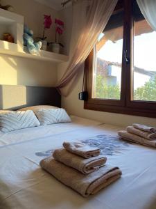 a bed with towels on it with a window at IslandTime Studio2 in Prinos
