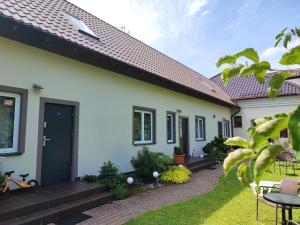 a house with a black door and a patio at DW "Wrzosek" in Wrzosowo