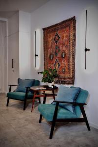 a living room with two chairs and a table and a rug at Lujza B studio 44 in Budapest