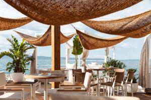 a restaurant with tables and chairs and hammocks at Radisson Blu Resort & Spa in Split