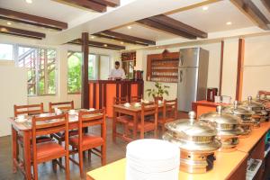 a restaurant with tables and chairs and a man in the kitchen at Hotel Splendid View in Pokhara
