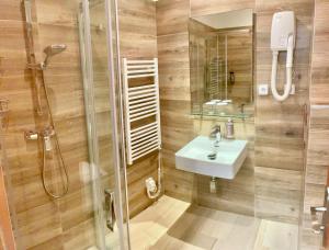 un bagno con doccia e lavandino di Hotel Atlas a Benešov