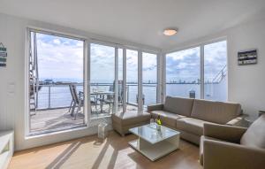 een woonkamer met een bank en een groot raam bij Hausboot in Olpenitz