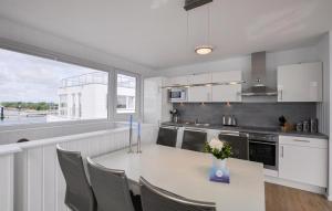 een keuken met een tafel met stoelen en een vaas met bloemen bij Hausboot in Olpenitz