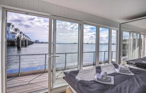een slaapkamer met uitzicht op het water vanaf een balkon bij Hausboot in Olpenitz +14 foto's