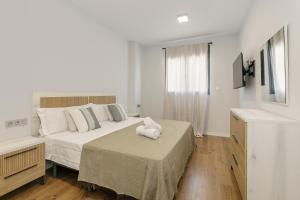 a bedroom with a bed with a white stuffed animal on it at Holiday Granada Ático Piscina y Parking in Granada +19 photos