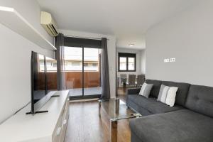 a living room with a couch and a table at Holiday Granada Ático Piscina y Parking in Granada