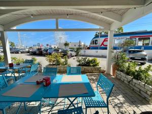 a blue table and chairs with a train in a parking lot at B&B Marina Sleep And Ship in Rodi Garganico