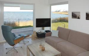 a living room with a couch and a chair and a television at Schlei Oase in Olpenitz