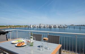 a table with food and wine glasses on a balcony at Küsten Lodge in Olpenitz