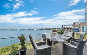 a table and chairs on a deck with a view of the water at Traumfänger in Olpenitz