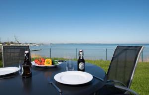 a table with two bottles of beer and a plate of fruit at Albatros in Olpenitz