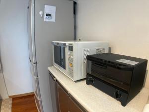 a kitchen counter with a microwave and a refrigerator at Tomi house in Kariya +19 photos