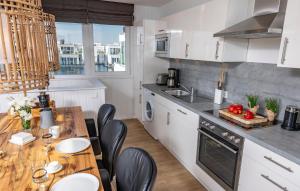 a kitchen with white cabinets and a wooden table at 10 Ost in Olpenitz
