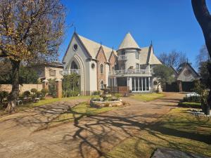 a large white house with a large driveway at Castle Home in Centurion