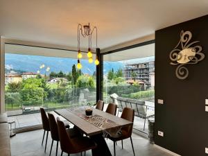 a dining room with a table and chairs and a large window at 1Dest - Riva Luxury Stay in Riva del Garda