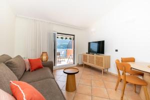 een woonkamer met een bank en een tafel bij Boka Apartment 1 in Herceg-Novi