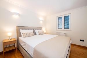een slaapkamer met een groot wit bed en een raam bij Boka Apartment 1 in Herceg-Novi