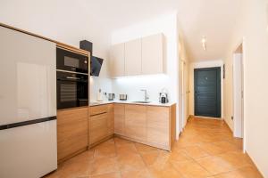 een keuken met houten kasten en een zwart-wit apparaat bij Boka Apartment 1 in Herceg-Novi
