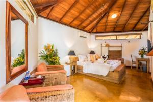 a bedroom with a bed and chairs in a room at Athulya Villas, Kandy in Kadugannawa