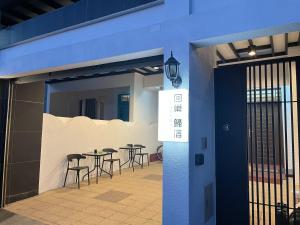 eine Terrasse mit Tischen und Stühlen in einem Gebäude in der Unterkunft Hui Chao Gui Su in Taitung
