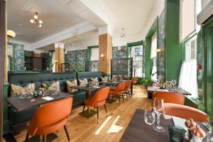a restaurant with green walls and tables and chairs at The Perle Oban Hotel & Spa in Oban