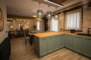 a kitchen with a counter and a dining room at Casa Vieja de la Abuela in Fuentesaúco de Fuentidueña