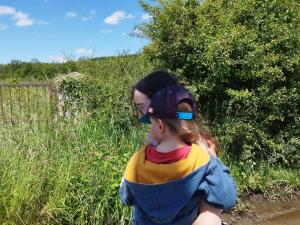 Eine Frau trägt ein kleines Mädchen auf einem Wanderweg in der Unterkunft Caravane en pleine nature ferme proche de tout in Philippeville