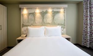 a bedroom with a large bed with two white pillows at President Hotel in London