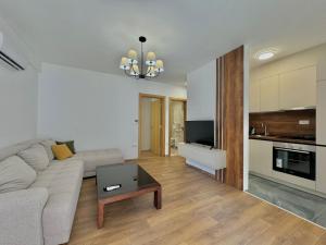 a living room with a couch and a table at One bedroom Apartment 777 in Budva +9 photos