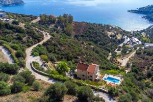 an aerial view of a house on a hill next to the water at Villa Lumière- Avantes in Agioi Apostoli