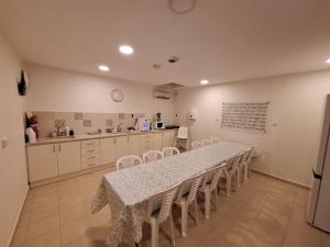 a dining room with a table and chairs and a kitchen at בית יעקב in Safed