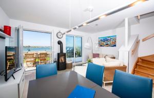 a living room with a dining room table and blue chairs at Villa Kunterbunt in Olpenitz