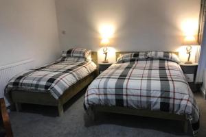 two beds in a room with two lamps on tables at The Pier Hotel in Aberystwyth