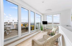 a living room with white walls and windows at Schleijuwel in Olpenitz +25 photos