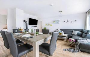 a dining room and living room with a table and a couch at Schleijuwel in Olpenitz