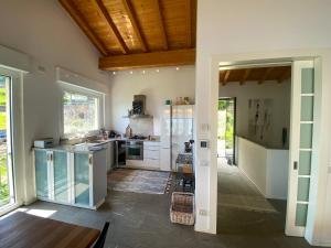 a kitchen with white cabinets and a wooden ceiling at Oasi Ulivi in San Siro
