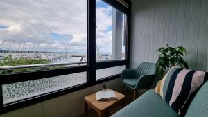 a room with two chairs and a table and two windows at FeWo Hafenkino in Laboe
