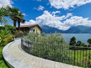 a house with a fence next to the water at Oasi Ulivi in San Siro